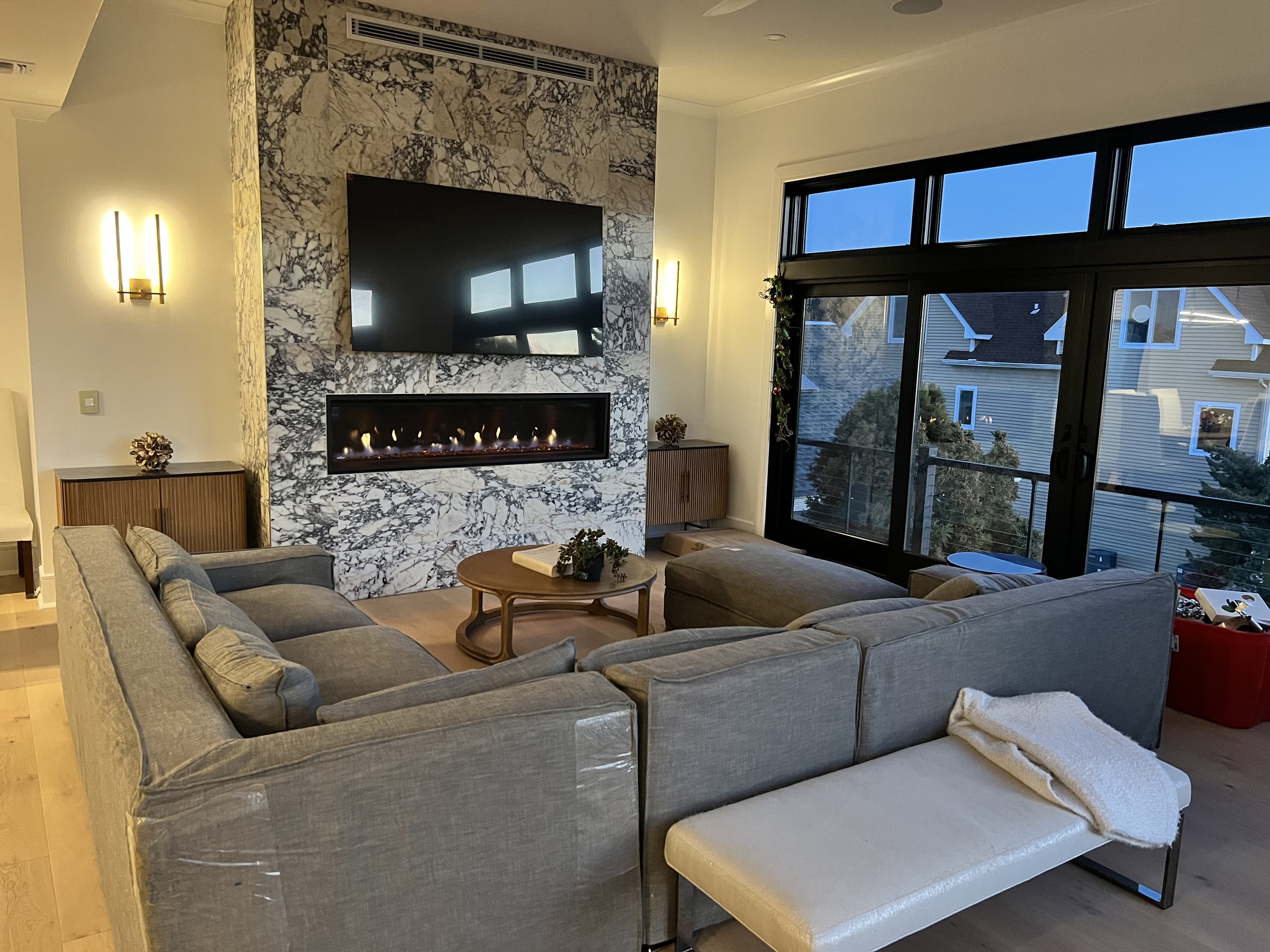 Modern family room with full-height marble fireplace wall and linear gas fireplace